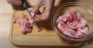 豚バラ肉をキッチンバサミで切るシーン