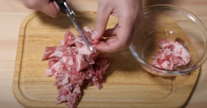 豚肉をキッチンバサミで切るシーン
